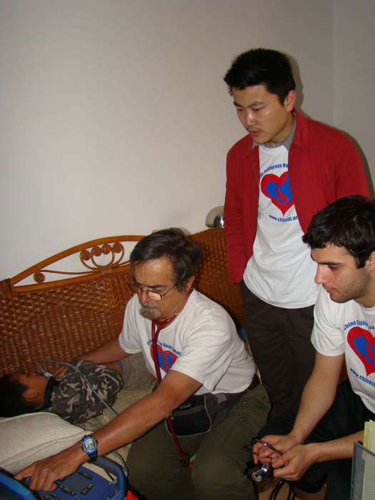 Huang Jie and Dr D and Martin study an patient